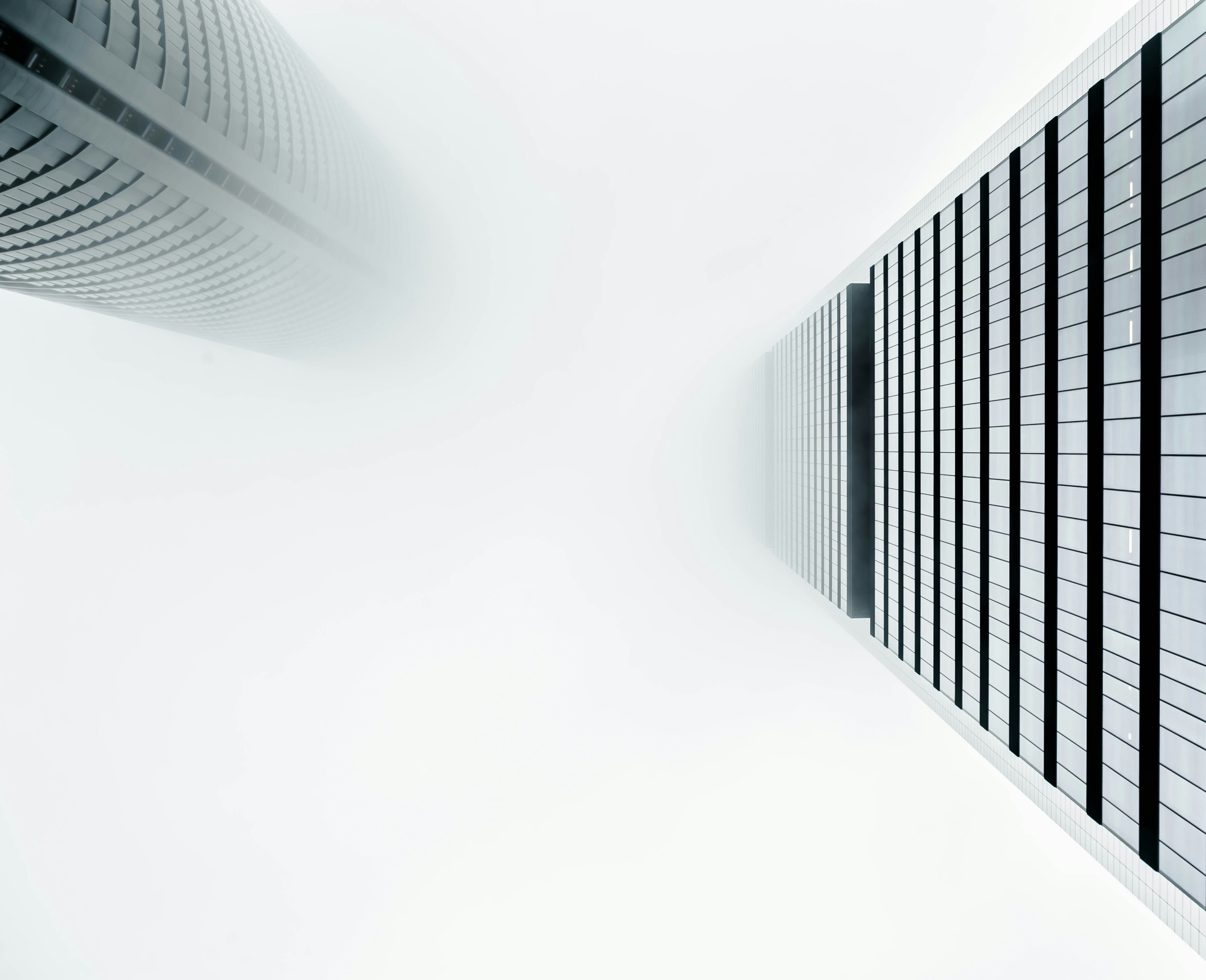 Looking up at buildings and white sky.